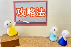 黒板を使って攻略法を指導する先生とそれを聞く生徒の人形のイメージ写真
